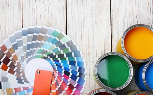 Cans with paint and color palette on wooden background, top view